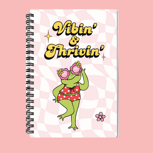A5 Vibin’ & Thrivin’ Notebook featuring a groovy retro frog design, hardback cover, spiral binding, and 100 lined pages for journaling and note-taking.