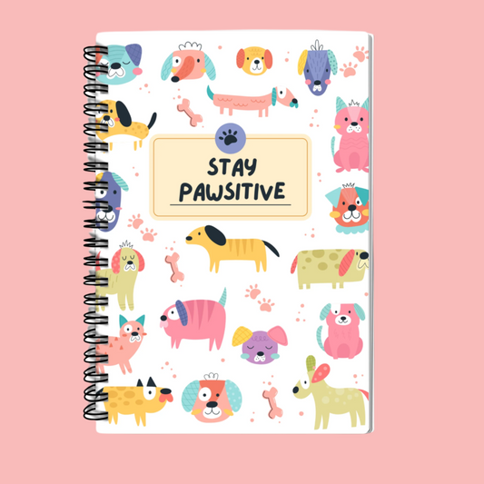 A5 Stay Pawsitive Dog Print Notebook with cute, playful design, spiral bound, featuring 100 lined pages for journaling, note-taking, and doodling. Perfect for dog lovers and pet enthusiasts.