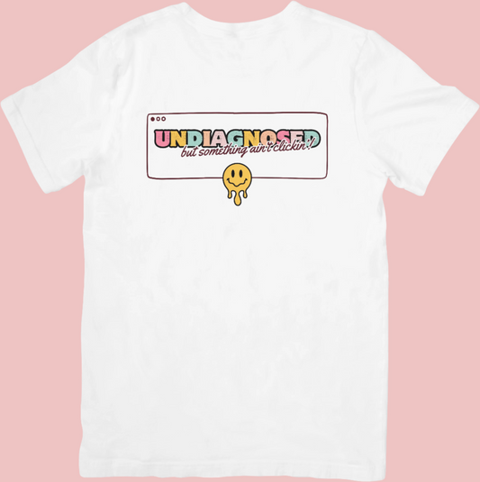 Retro-style crew neck t-shirt with a smiley face design and the phrase ‘Undiagnosed: But The Math Ain’t Mathin’,’ celebrating neurodivergence and embracing the journey.